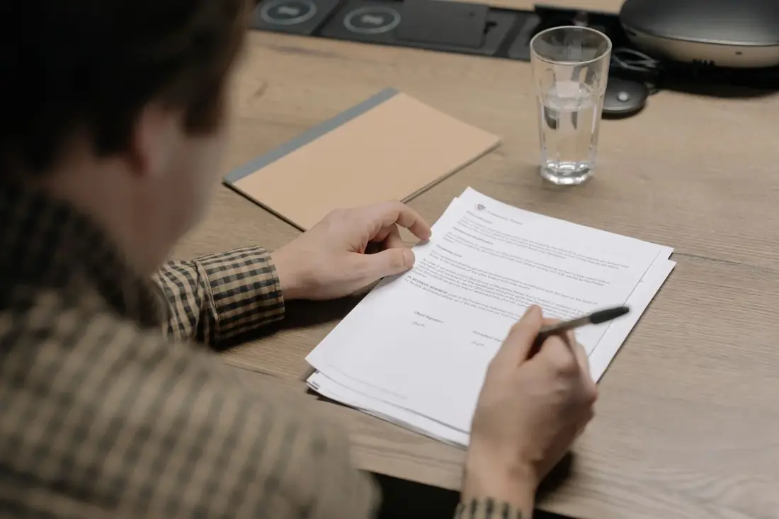 Person reviewing a we buy houses cash offer contract at a table