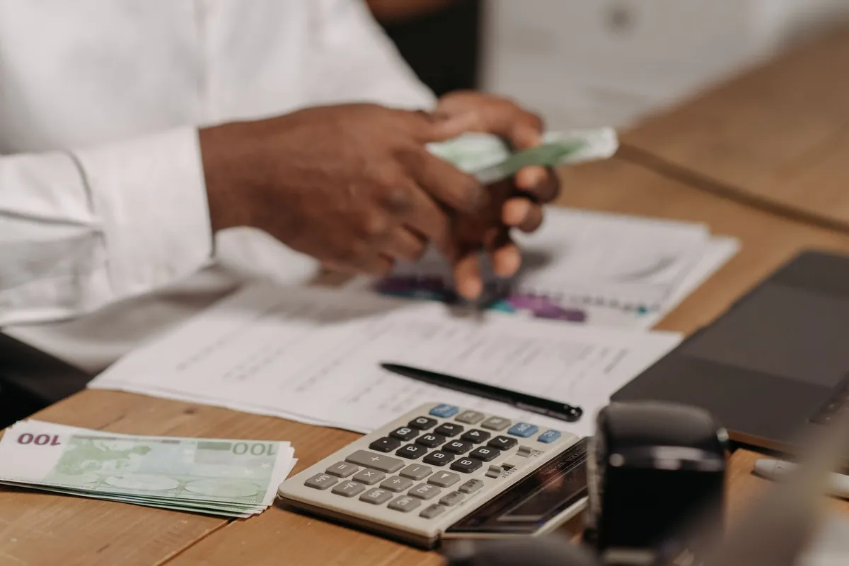 Counting cash next to paperwork, illustrating the real costs of a real estate auction