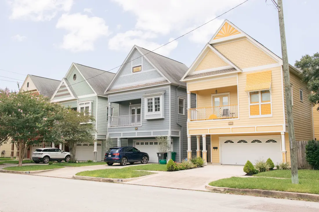 Two similar Iowa houses side by side on a street, a cash home buyer vs iBuyer comparison