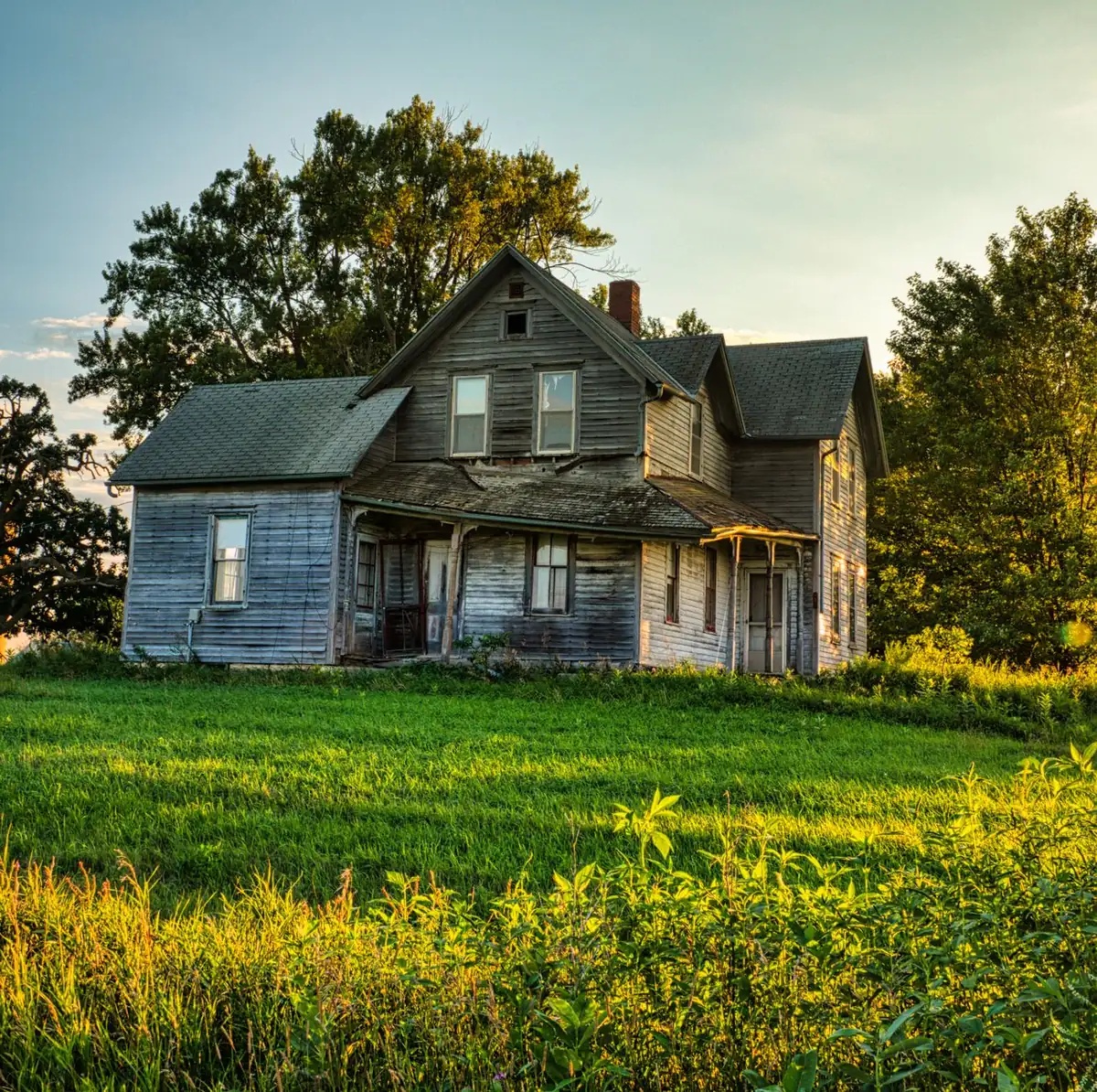 An older farmhouse in the rural Iowa countryside, the kind of property an iBuyer skips but a local cash buyer will still purchase