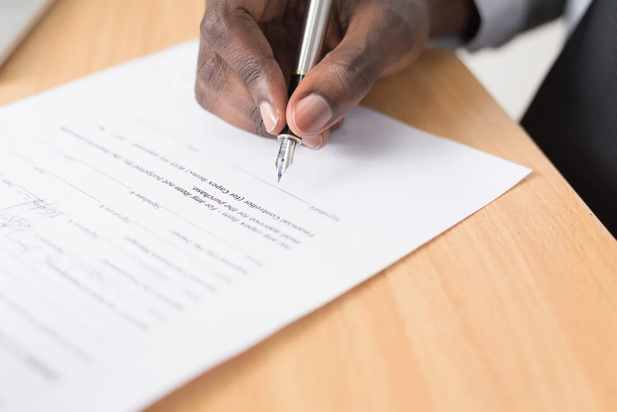 Homeowner signing foreclosure defense paperwork with a lawyer