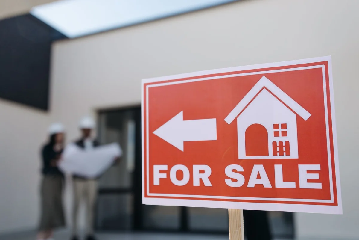 A for sale sign in front of a house listed in Iowa