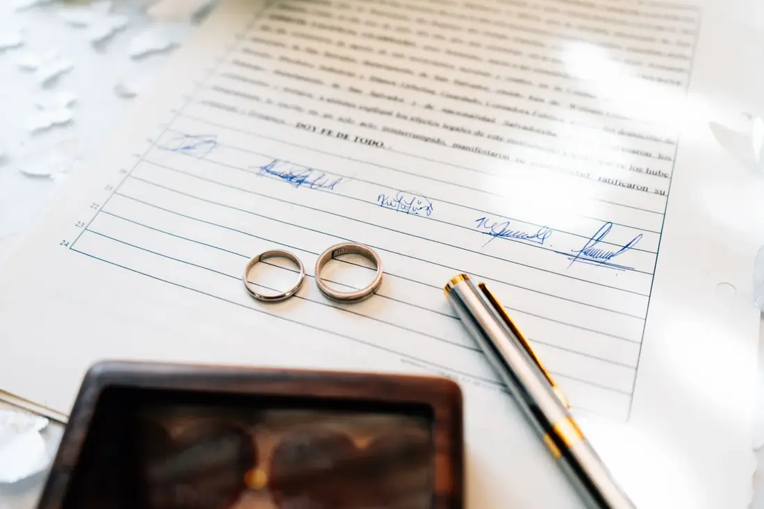 Wedding rings on legal documents during an Iowa divorce home sale