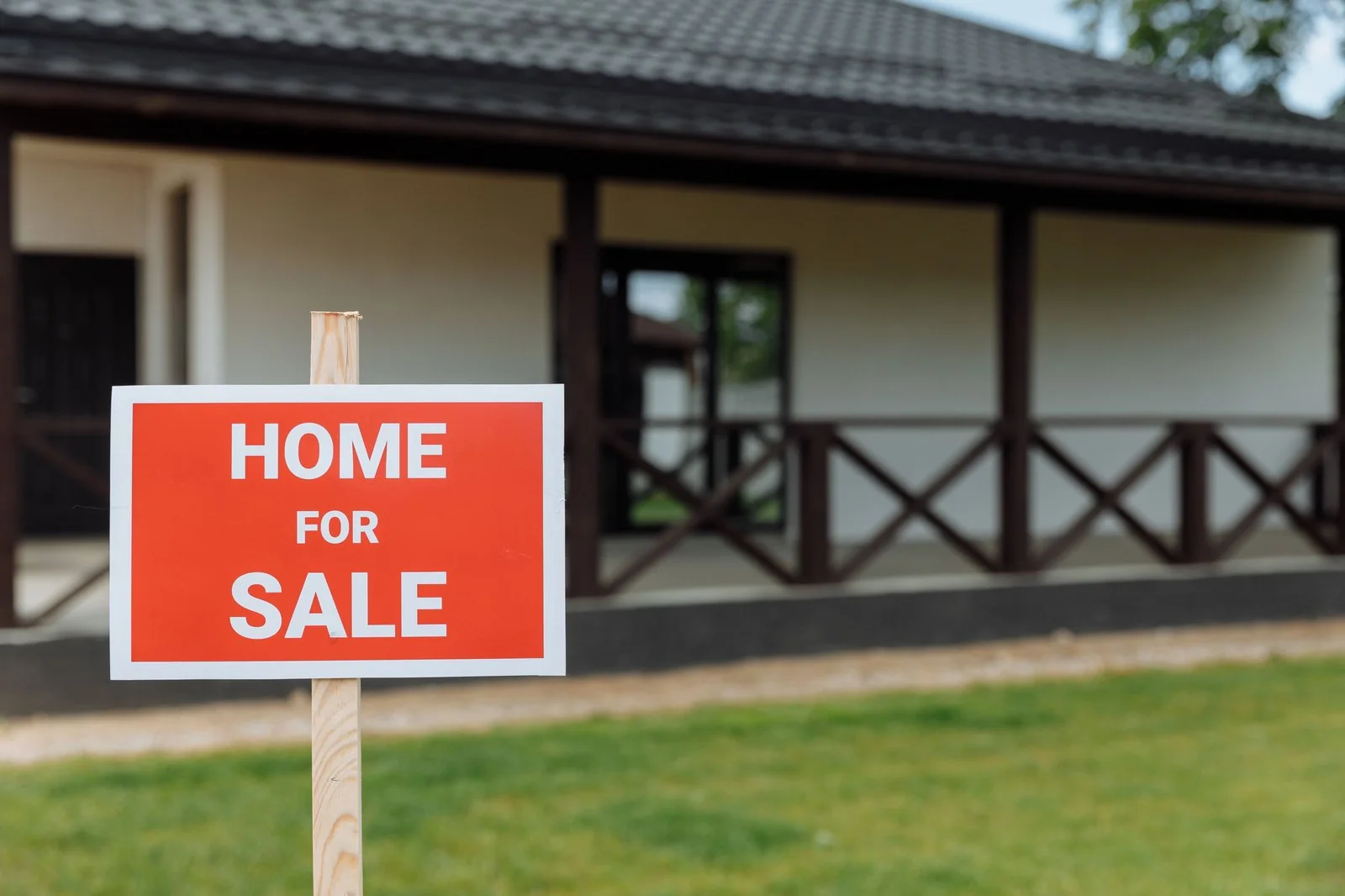 A for-sale sign in a yard comparing an MLS listing to a cash buyer