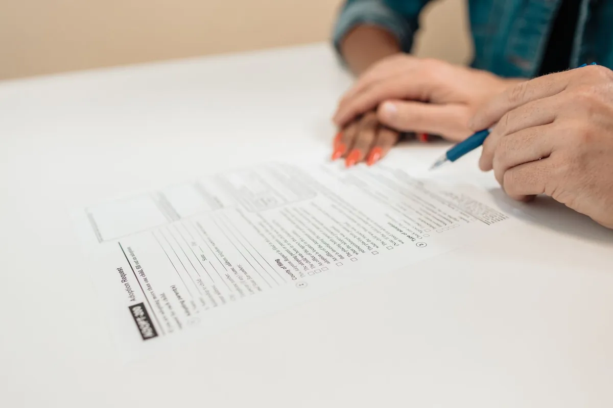 A person signing a real estate contract for deed at a table in Iowa