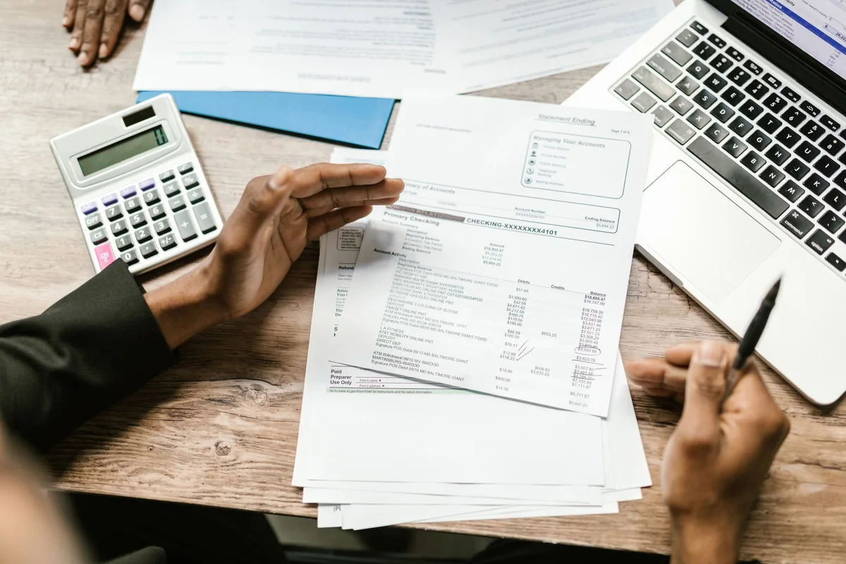 Insurance and mortgage documents spread across a desk, deciding who keeps the proceeds when selling a house with an open insurance claim