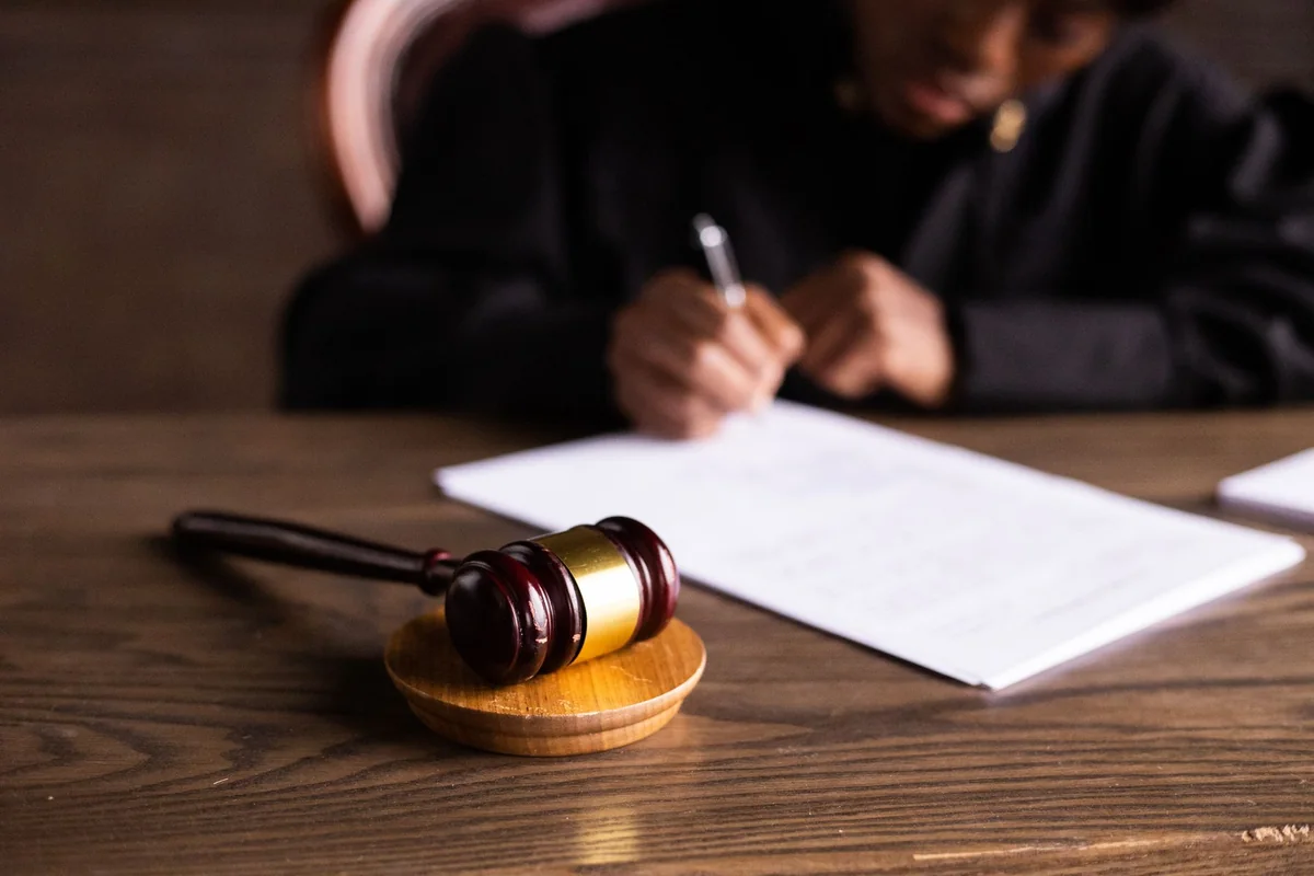 A judge signing court papers, the kind of pending case that triggers a lis pendens on an Iowa house
