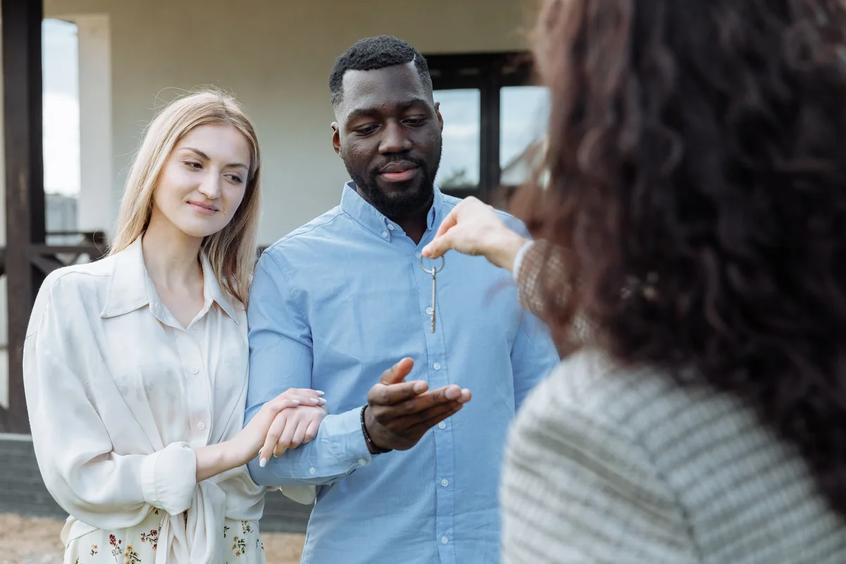 A person handing over house keys, showing a cash buyer closing after clearing a quitclaim title question