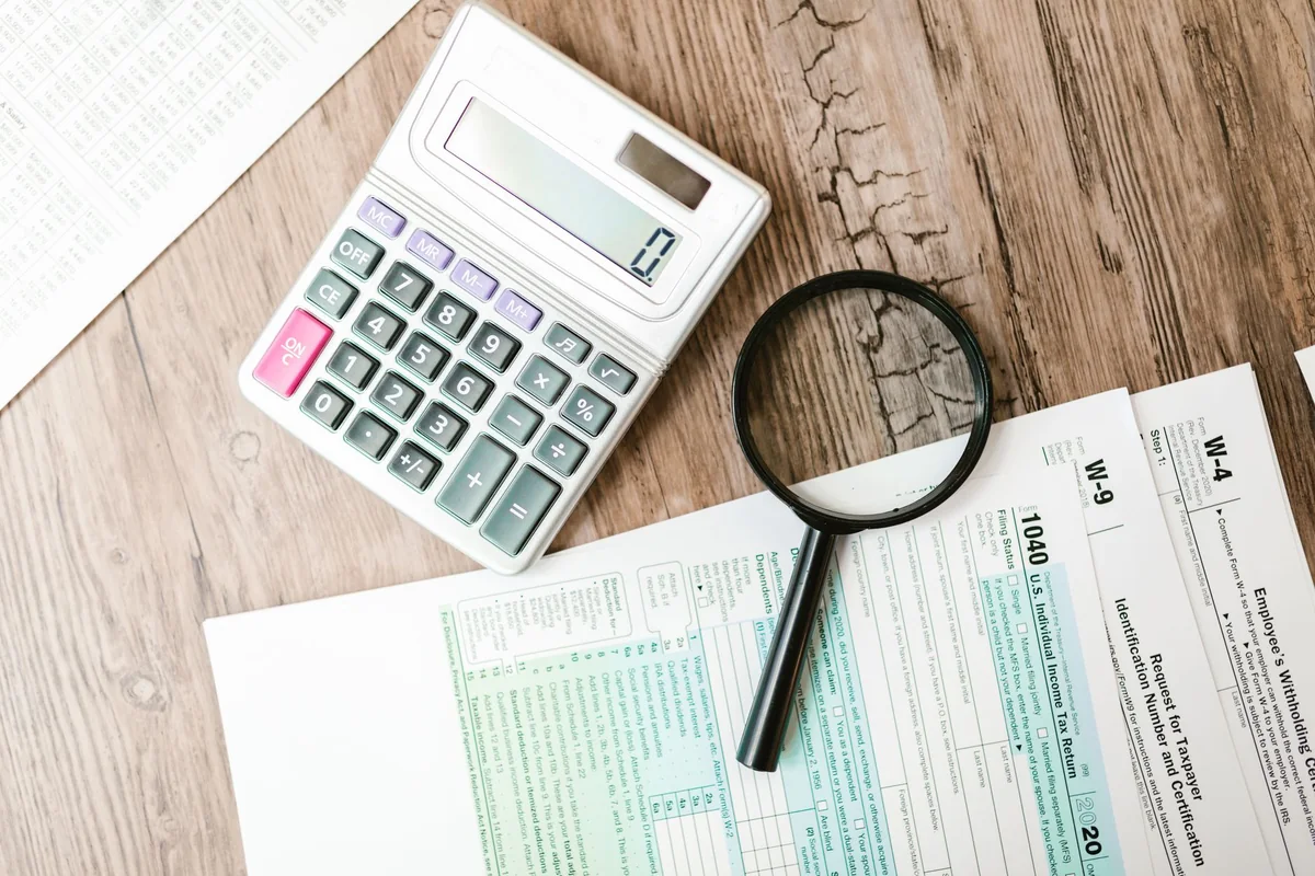 A magnifying glass over documents, representing a title examiner reviewing a quitclaim in the chain of title