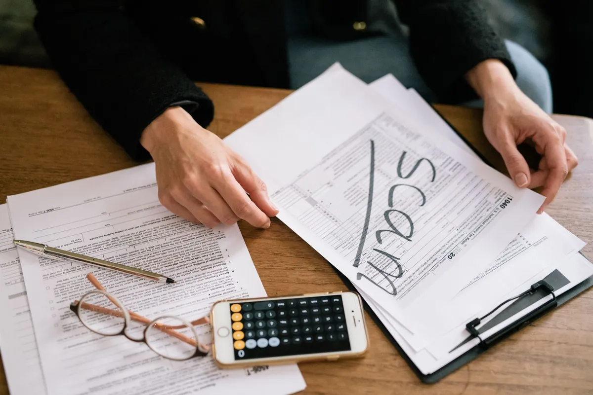 Tax forms and a calculator on a desk, the capital gains and depreciation math when selling a rental property in Iowa