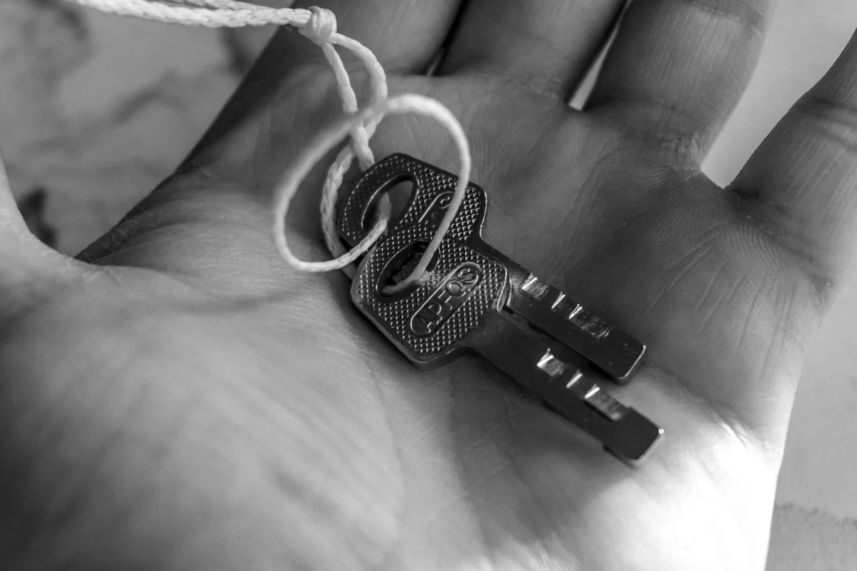 Holding two house keys, representing bridging the gap between selling and buying