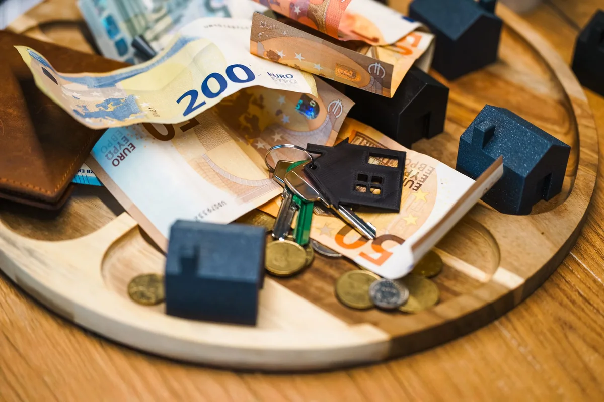 House keys and money representing the value of a house in poor condition