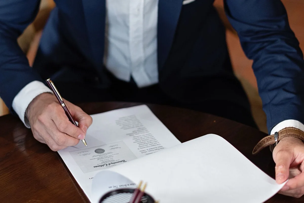 An executor signing legal documents to sell a probate house