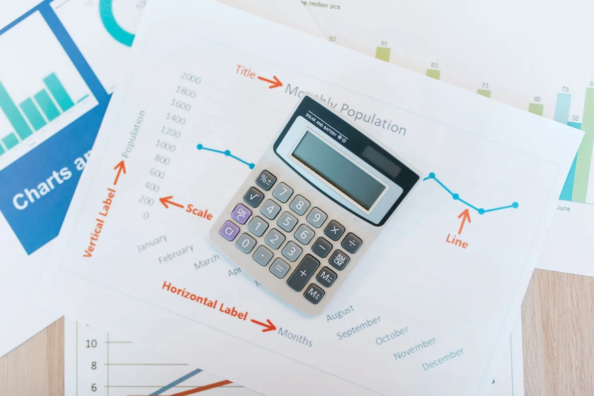 A calculator on financial paperwork, showing the credit cost of short sale vs. foreclosure