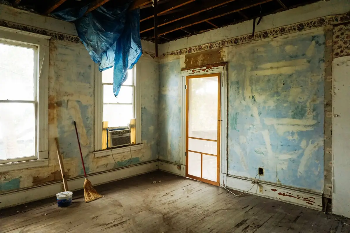 A bucket and broom in a home being renovated after an as-is sale in Iowa
